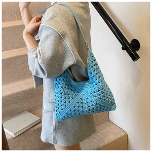 Détail d'un sac hobo au crochet bleu tissé à la main avec motif géométrique ajouré