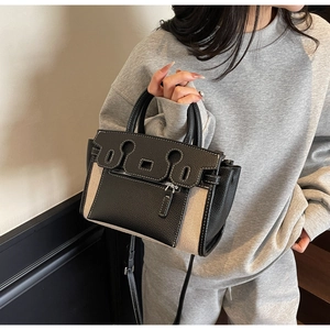 Detail of contrast stitch canvas handbag with leather trim and silver zipper hardware