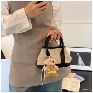 Close-up of contrast tote bag with a cute bear charm in a lifestyle home setting
