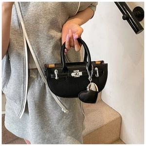Detail of black pebbled leather half-moon bag with silver lock and heart charm