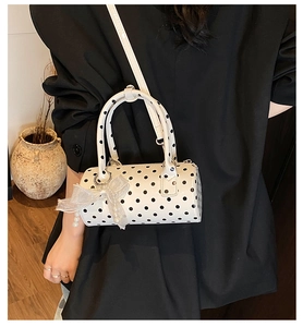 Polka dot cylinder bag featuring a white organza bow and pearl charm detail