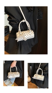 Detail view of white polka dot cylinder handbag with lace pearl bow and shoulder strap