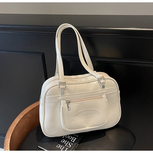Detail of a creamy white leather Boston bag featuring an embossed Noronoro logo design
