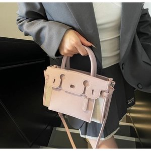 Detail of pink lychee leather and beige canvas Kelly bag with silver hardware accents