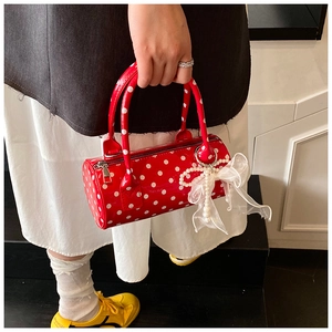 Detailed shot of red polka dot cylinder handbag with pearl and lace bow charms