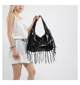 Vue détaillée d'un sac bandoulière en cuir noir avec de longues franges bohèmes chic