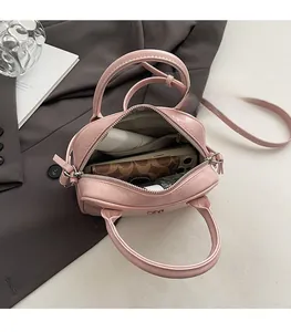 Vue détaillée d'un sac à main rose montrant le rangement du téléphone et du maquillage