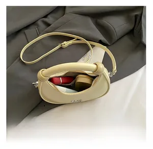 Interior view showing lipstick and powder in a yellow crescent-shaped leather bag