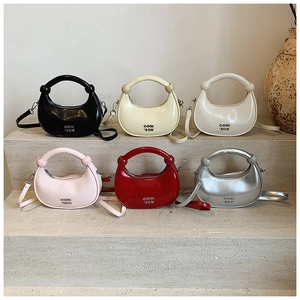Crescent handbags in six colors displayed on stone steps with polished finish