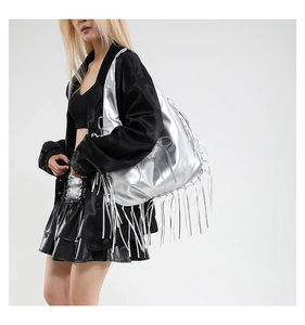 Sac hobo argenté métallisé avec de longues franges porté par un mannequin en studio