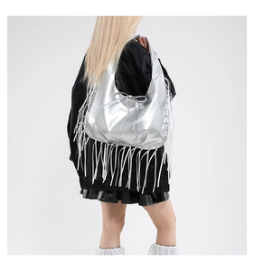 Detail of silver metallic hobo bag with fringe tassels and a bow accent on the side