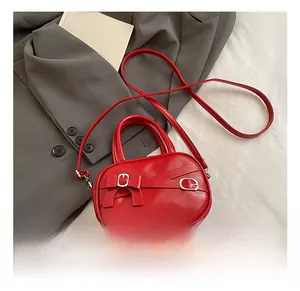 Detail of red bowling handbag with decorative bow and silver metal buckle on strap