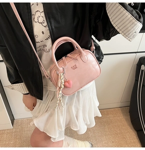 Détail du mini sac Boston rose avec logo PAN'TOR et breloque pendentif coeur