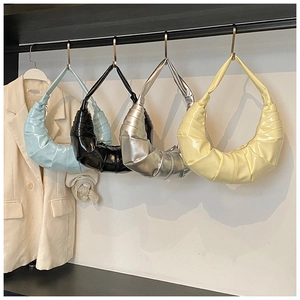 Detail showing various colors of ruched crescent hobo bags in glossy vegan leather
