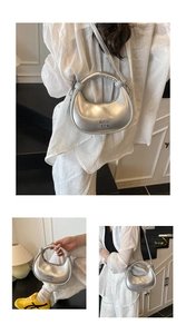 Detail of silver crescent bag with metallic finish showing handle and shoulder strap