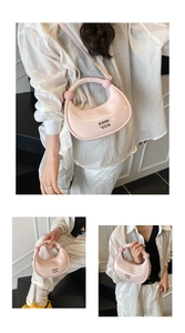 Pink crescent handbag detail with glossy finish, metal logo, and beaded handle accents