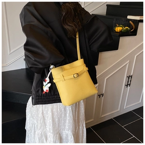 Sac seau jaune vif avec texture litchi et charme de canard porté par un mannequin