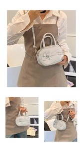 Detail of cream patent leather bowling bag with bow strap and silver buckle hardware