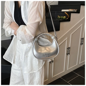 Detail of silver crescent bag featuring ruched handle and GOIH T2DN logo design
