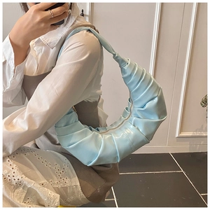 Close-up of light blue pleated croissant bag with premium glossy patent texture finish