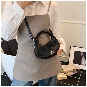 Detail of black crescent handbag with round handle and adjustable crossbody strap