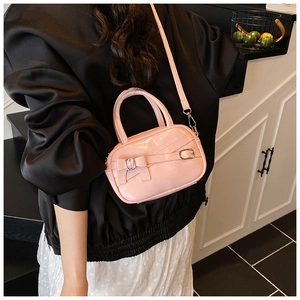 Detail of pink glossy patent leather bowling bag with bow and silver buckle accents