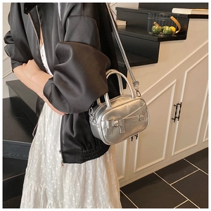 Silver bow accent bowling bag shown with adjustable strap on a model in a modern room
