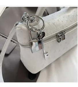 Macro detail of white ostrich textured leather purse with silver lock and key hardware
