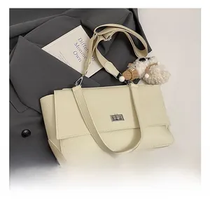Detail of off-white lychee leather texture with silver clasp and plush bear charm