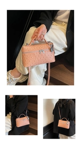 Detail of pink ostrich pattern handbag showing silver hardware and smooth handle texture