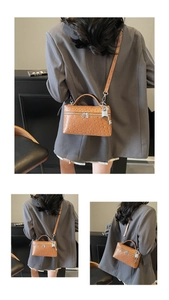 Detailed view of brown ostrich-embossed mini box bag with silver hardware and padlock