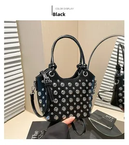 Detailed shot of a black bucket bag with silver studs and adjustable shoulder strap