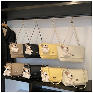Close-up of four colors of large soft leather tote bags with bear charms and metal locks