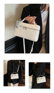 Detailed view of white ostrich pattern handbag with silver hardware and top handle