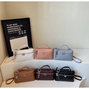 Detail view of colorful ostrich texture handbag collection with metal lock and shoulder strap