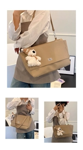 Detail of khaki leather business briefcase with silver turn-lock and plush bear charm