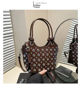 Detail view of coffee brown bucket bag with decorative silver rivets and round handle