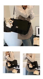 Close-up of black leather tote bag featuring a silver rectangular twist lock and bear charm