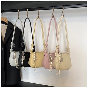 Detail of small bucket bags in multiple colors featuring unique knotted straps and charms