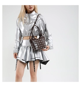 Detail of dark brown leather bucket bag with silver stud rivets and top handle style