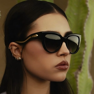 Lunettes de soleil œil de chat pour femmes avec monture noire et branches serpent dorées