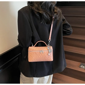 Pink ostrich pattern mini handbag with silver hardware shown as crossbody style