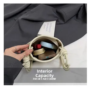 Detail view of large internal capacity showing phone and makeup in beige bucket bag