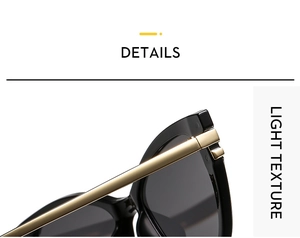 Close-up of golden metal hinge on black cat-eye sunglasses with grey lenses