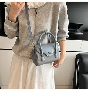 Détail du sac bandoulière bleu gris avec rabat grainé et corps à texture tissée