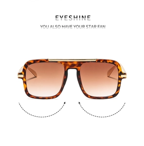 Detail of square oversized tortoiseshell sunglasses with brown gradient lenses and gold bar