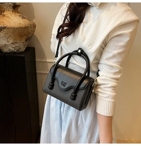 Détail du sac bandoulière noir avec logo PAN TOR sur un fond intérieur minimaliste