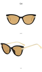 Detail view of cat-eye sunglasses with yellow lenses and golden metallic temples
