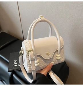 Détail d'un mini sac à main blanc crème avec cuir tressé et logo métallique PAN TOR