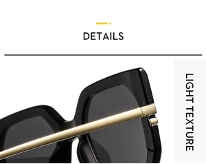 Close-up of black oversized frame sunglasses with slim gold metal temples and dark lenses